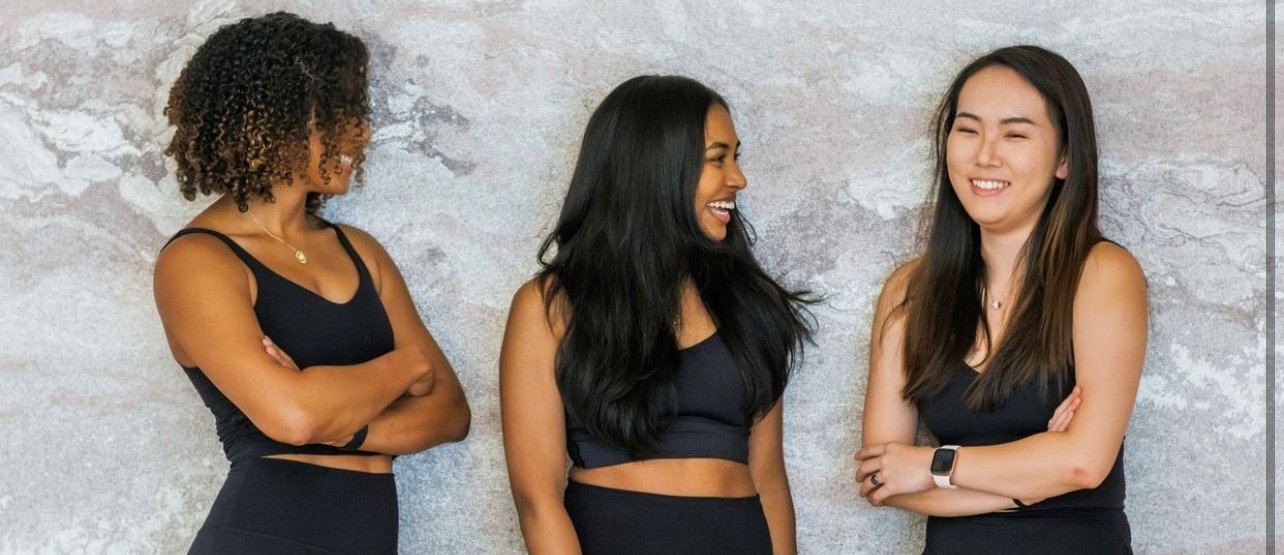 Three girls dressed in black Mind Body Fitness Class