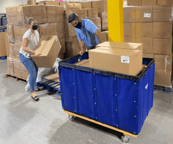 volunteer 342x285 (5)-min volunteer putting boxes on moving trolley