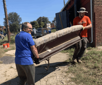 two people shifting furniture